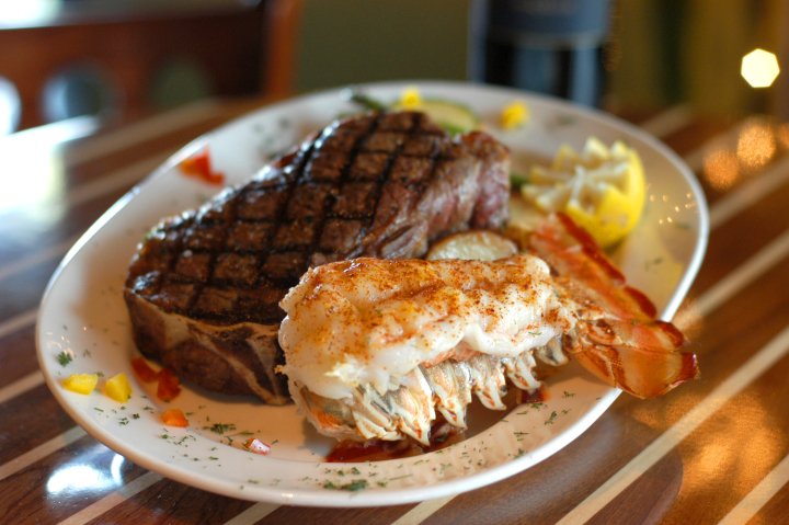 Middle Grounds Grill-min (1) Grilled steak and lobster tail served with lemon and garnishes, representing the culinary offerings at Middle Grounds Grill in Treasure Island.