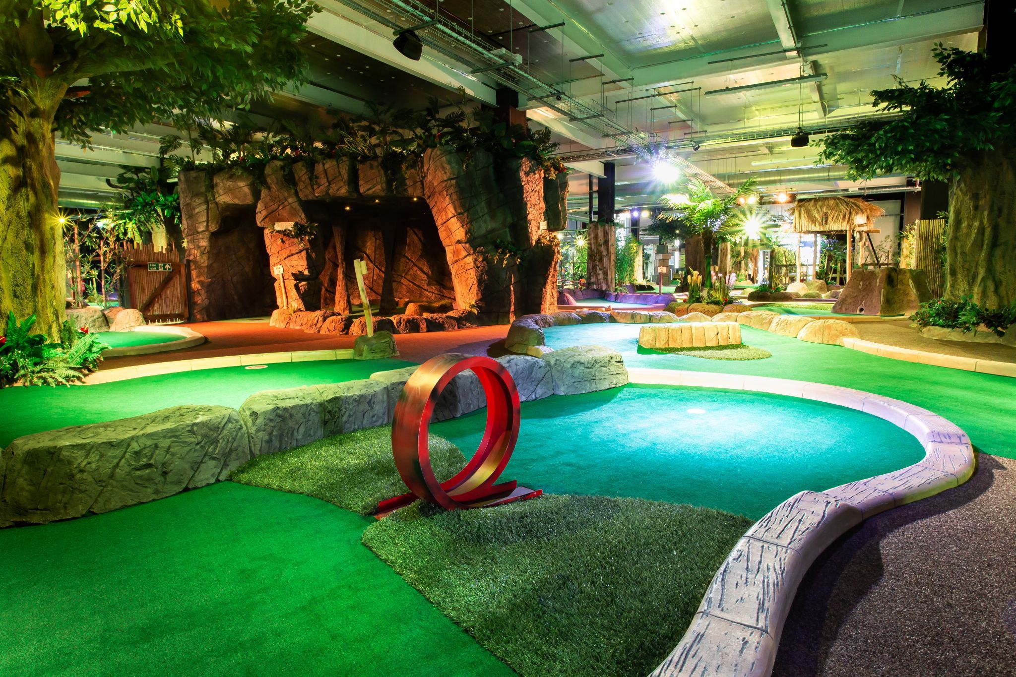 Paradise Island Mini Golf-min Whimsical mini-golf course at Paradise Island Mini Golf in Treasure Island, featuring vibrant greens, rocky landscaping, and playful obstacles for family-friendly fun.